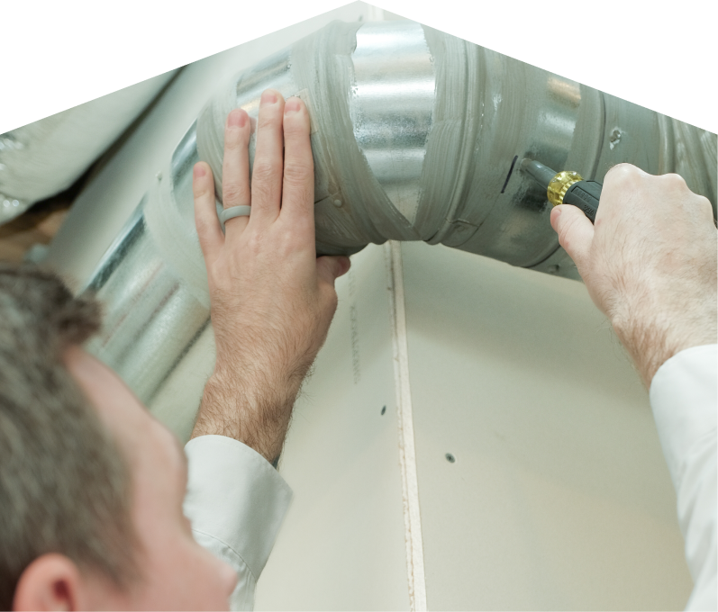 Home Aire Care HVAC technician inspecting and tightening a joint on a sealed metal air duct, performing maintenance work during an air duct cleaning task. Home Aire Care HVAC technician inspecting and tightening a joint on a sealed metal air duct, performing maintenance work during an air duct cleaning task.