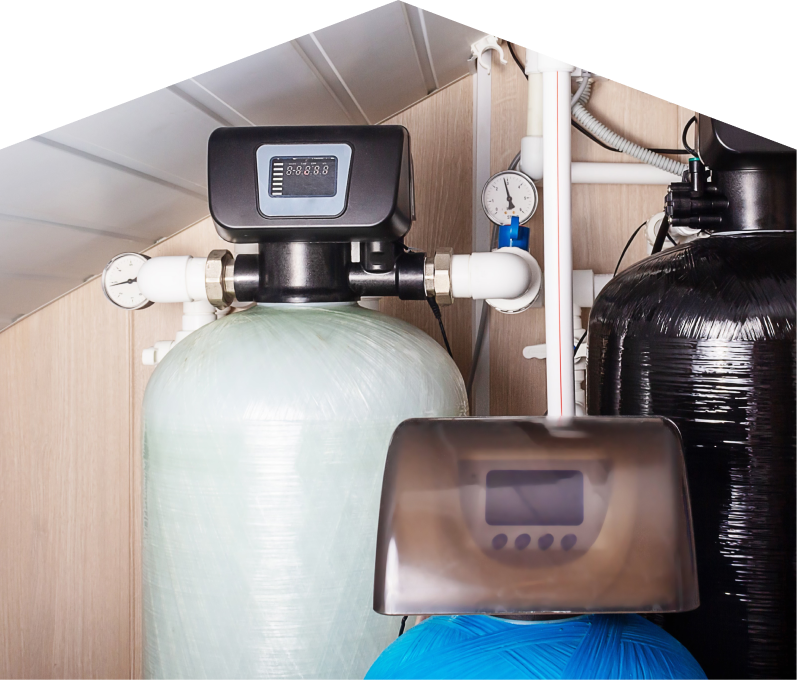 Home Aire Care home water filtration system featuring resin tanks, digital control heads, pressure gauges, and connected piping in a utility room. Home Aire Care home water filtration system featuring resin tanks, digital control heads, pressure gauges, and connected piping in a utility room.
