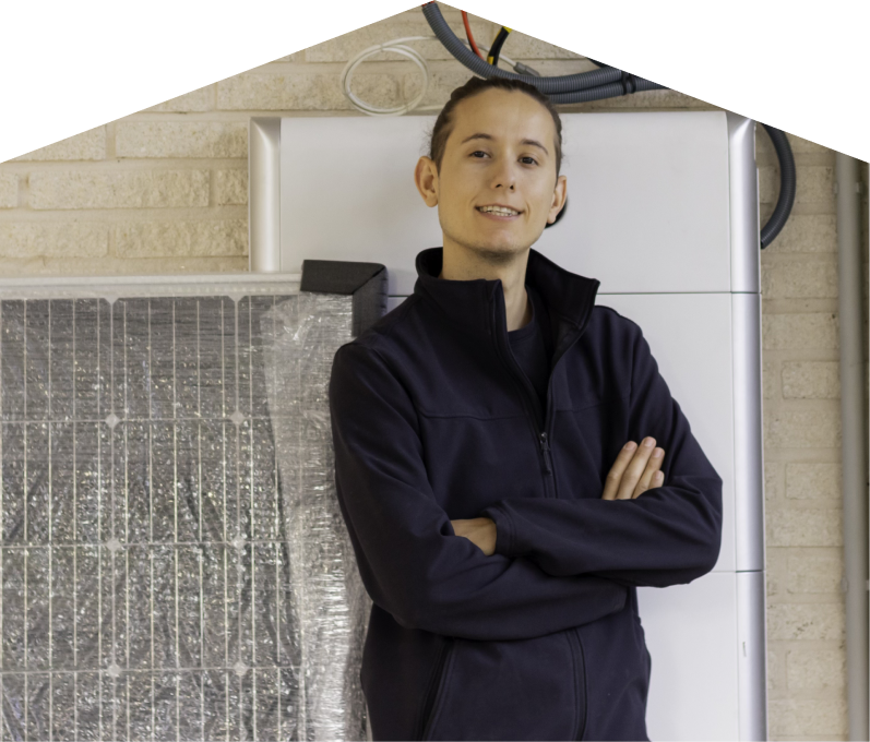 Home Aire Care specialist standing confidently with arms crossed beside newly delivered system components, including a wrapped panel and wall-mounted utility unit. Home Aire Care specialist standing confidently with arms crossed beside newly delivered system components, including a wrapped panel and wall-mounted utility unit.